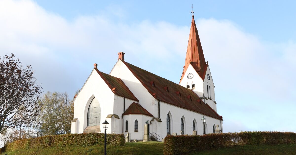 赤い屋根と尖塔が特徴の白い教会建築