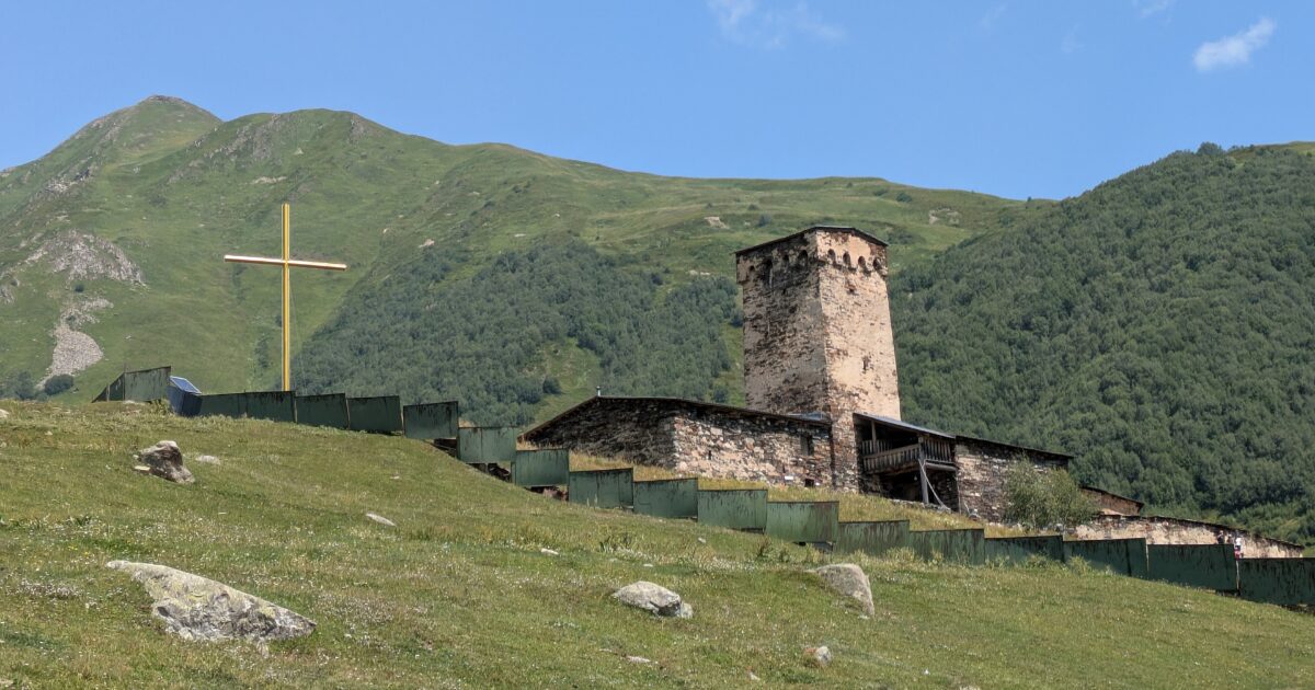 山岳地帯に佇む石造り教会と十字架