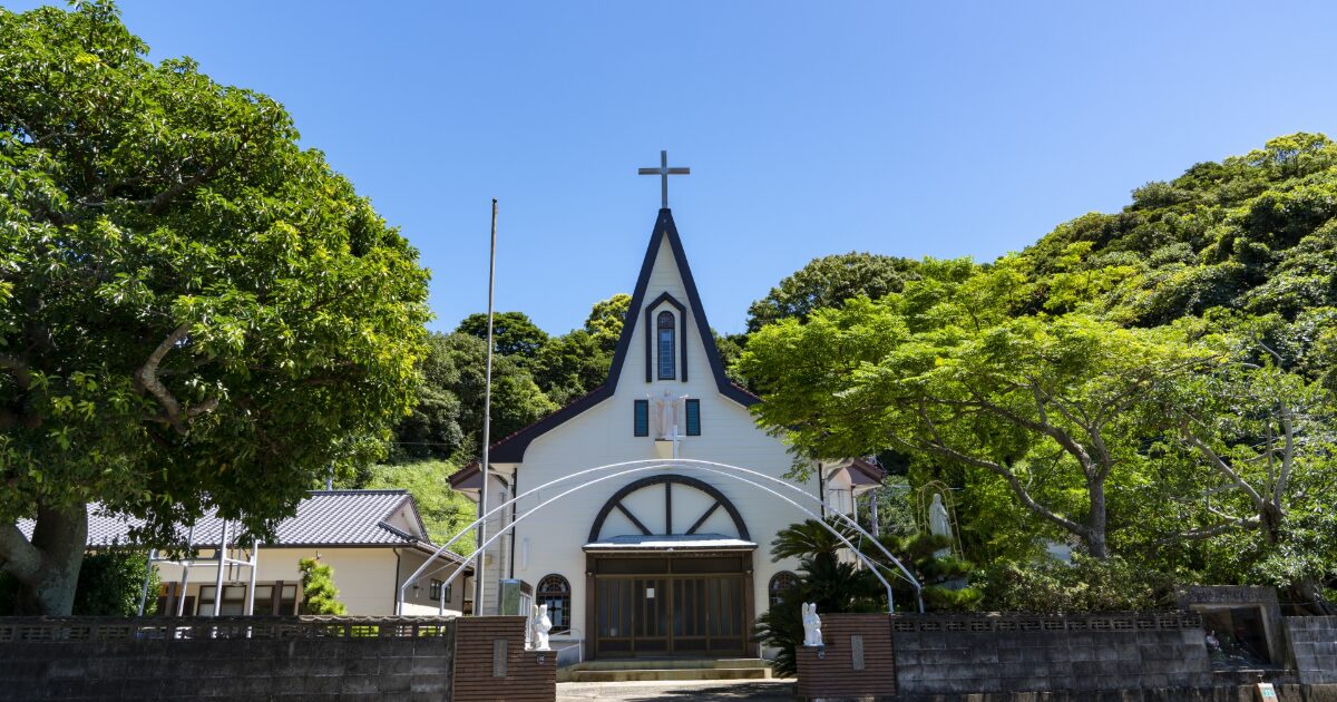 緑に囲まれた小さな白い教会正面外観