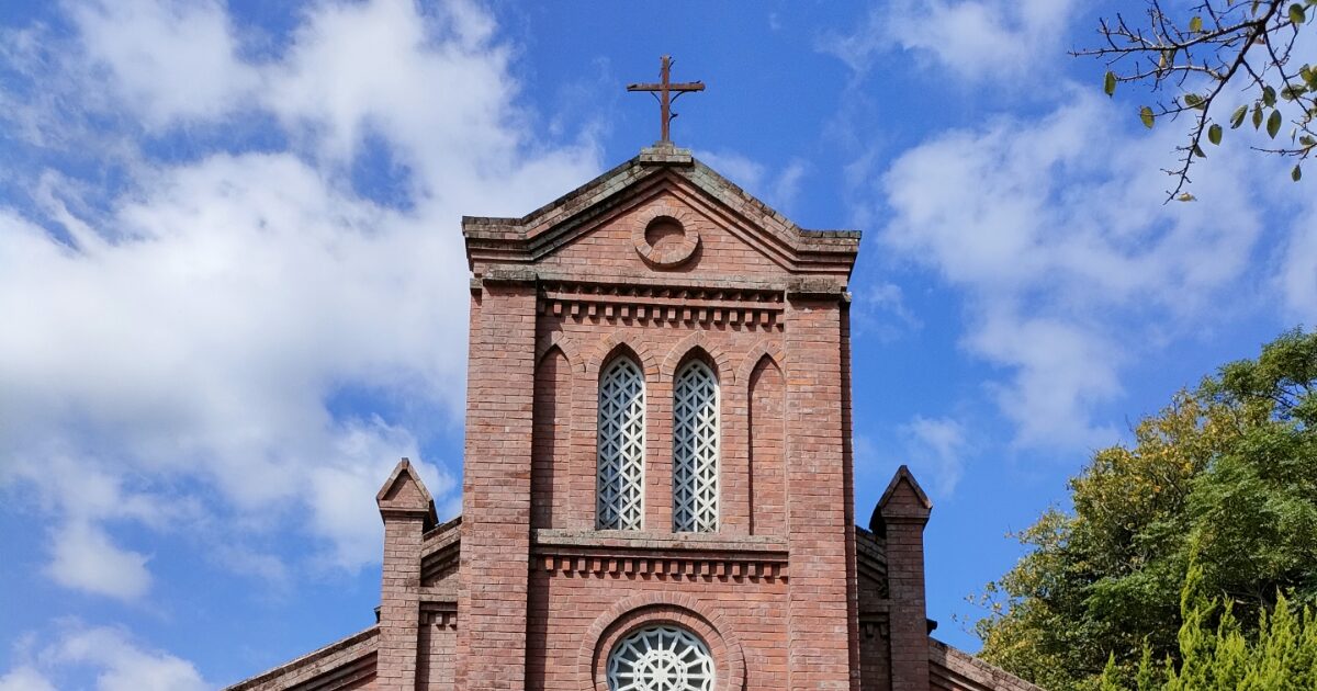 青空に映える赤レンガ造り教会の正面外観